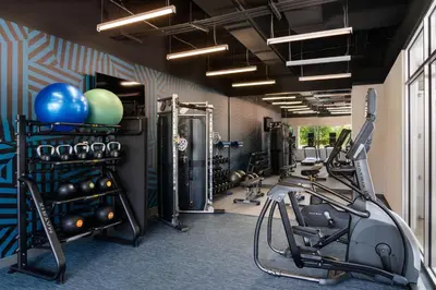 a gym with a treadmill and exercise equipment in a room at Aloft Beachwood in Beachwood