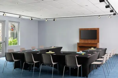 a conference room with a table and chairs and a tv at Aloft Beachwood in Beachwood