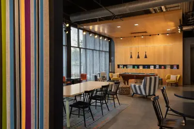 a dining room with tables and chairs and a table and a table and chairs at Aloft Beachwood in Beachwood