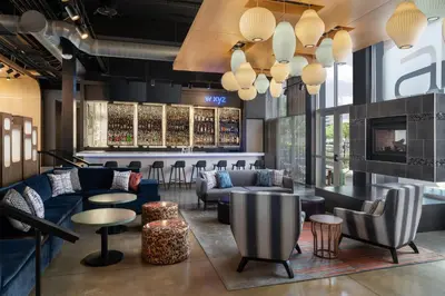 a lobby with couches and tables and a bar at Aloft Beachwood in Beachwood
