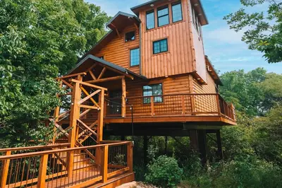 a large wooden house with a tower on top at Skyview Treehouse A by Amish Country Lodging in Millersburg