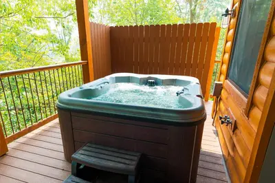 a hot tub sitting on a deck on a porch at Skyview Treehouse A by Amish Country Lodging in Millersburg