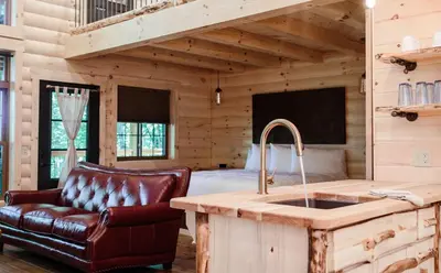 a kitchen with a sink and a leather chair at Skyview Treehouse A by Amish Country Lodging in Millersburg