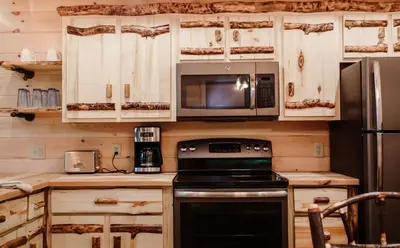 a kitchen with a stove and a microwave at Skyview Treehouse A by Amish Country Lodging in Millersburg