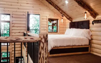 a bedroom with a bed in a log cabin at Skyview Treehouse A by Amish Country Lodging in Millersburg
