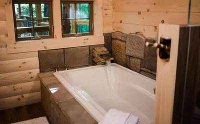 a bathroom with a large tub in a cabin at Skyview Treehouse A by Amish Country Lodging in Millersburg