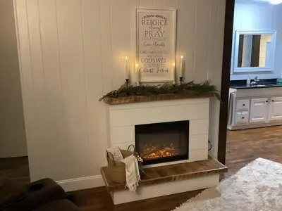 a living room with a fireplace with two candles at Farmhouse of Blessings in Dundee
