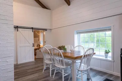a dining room with a table and chairs and a window at Farmhouse of Blessings in Dundee