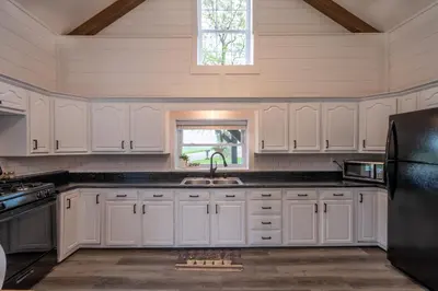 a kitchen with white cabinets and a sink and a window at Farmhouse of Blessings in Dundee
