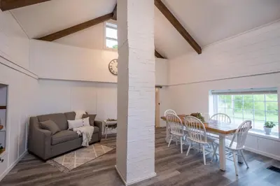 a dining room and living room with a table and chairs at Farmhouse of Blessings in Dundee