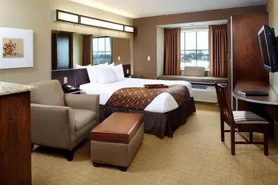 a hotel room with a king sized bed and a desk at Microtel Inn & Suites by Wyndham St Clairsville - Wheeling in Saint Clairsville