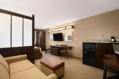 a living room with a couch and a dining room at Microtel Inn & Suites by Wyndham St Clairsville - Wheeling in Saint Clairsville