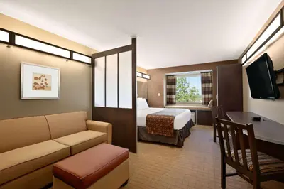 a hotel room with a bed and a couch at Microtel Inn & Suites by Wyndham St Clairsville - Wheeling in Saint Clairsville