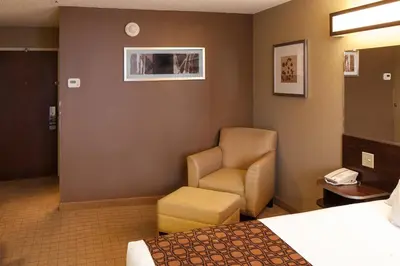 a hotel room with a bed and a chair at Microtel Inn & Suites by Wyndham St Clairsville - Wheeling in Saint Clairsville