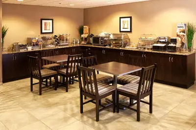 a restaurant with a bar with chairs and tables at Microtel Inn & Suites by Wyndham St Clairsville - Wheeling in Saint Clairsville