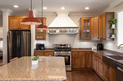 a kitchen with wooden cabinets and stainless steel appliances at 80 Acres, Pool, Game room with Ping Pong & Billiards! in Williamstown
