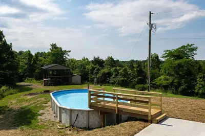 a swimming pool with a bench and a gazebo at 80 Acres, Pool, Game room with Ping Pong & Billiards! in Williamstown