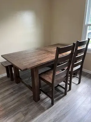 a wooden dining room table with two chairs around it at Cottage near Cedar Point and downtown Sandusky in Sandusky