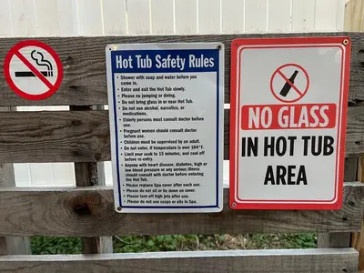 two signs are posted on a wooden fence at Cottage near Cedar Point and downtown Sandusky in Sandusky