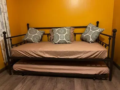 a bed with pillows on it in a room at Cottage near Cedar Point and downtown Sandusky in Sandusky