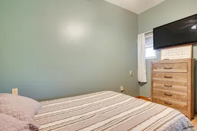 a bedroom with a bed and a dresser with a flat screen tv at Quaint Zanesville Home with Game Room and Yard! in Zanesville