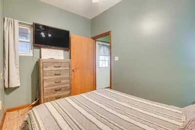 a bedroom with a bed and a dresser and a television at Quaint Zanesville Home with Game Room and Yard! in Zanesville