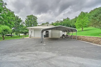 a large parking lot with a cover in front of a house at Quaint Zanesville Home with Game Room and Yard! in Zanesville