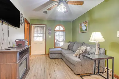 a living room with a couch and a flat screen tv at Quaint Zanesville Home with Game Room and Yard! in Zanesville
