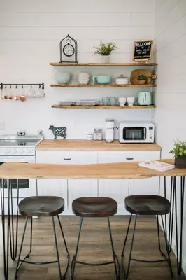 a kitchen with two stools in front of a counter at Cozy Cottage on 250 Acre Dairy Farm Near Ark in Dry Ridge