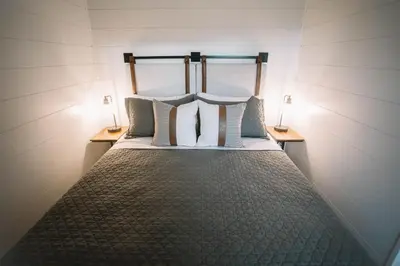 a bed in a room with two lamps on tables at Cozy Cottage on 250 Acre Dairy Farm Near Ark in Dry Ridge
