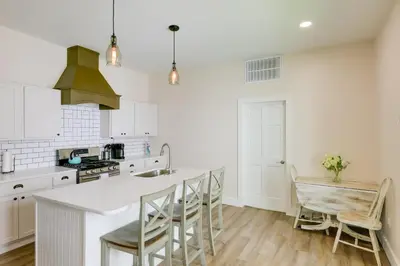 a kitchen with white cabinets and a table and chairs at Historic Madison Retreat - 1 Mi to Ohio River in Madison