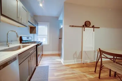 a kitchen with a sink and a table at 3 Mi to Dtwn Walkable Apt in Cleveland! in Cleveland