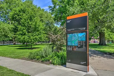 a sign in a park next to a sidewalk at 3 Mi to Dtwn Walkable Apt in Cleveland! in Cleveland