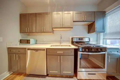 a kitchen with wooden cabinets and a stove top oven at 3 Mi to Dtwn Walkable Apt in Cleveland! in Cleveland