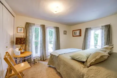 a bedroom with a bed and a table and windows at BBQ, Fire Pit and Yard Family Home in Adrian in Adrian