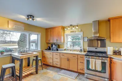 a kitchen with wooden cabinets and a stove top oven at Central and Private Milan Home about 10 Mi to Sandusky! in Milan