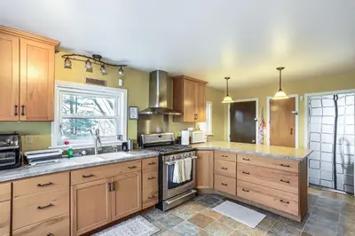 a kitchen with wooden cabinets and a stove top oven at Central and Private Milan Home about 10 Mi to Sandusky! in Milan