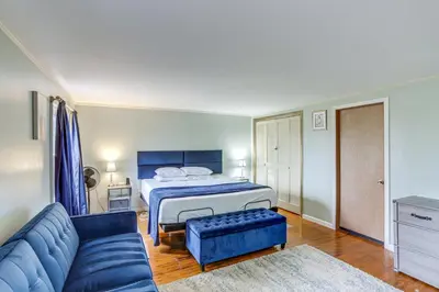 a bedroom with a bed and a blue couch at Central and Private Milan Home about 10 Mi to Sandusky! in Milan