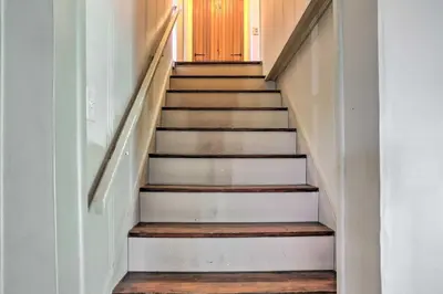 a staircase in a house with wooden floors and a door at Central and Private Milan Home about 10 Mi to Sandusky! in Milan