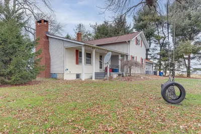 a house with a tire in the yard at Central and Private Milan Home about 10 Mi to Sandusky! in Milan