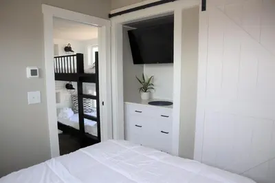 a bedroom with a bed with a television and a staircase at Bayfront Resort at Cross View Site #28 in Sandusky