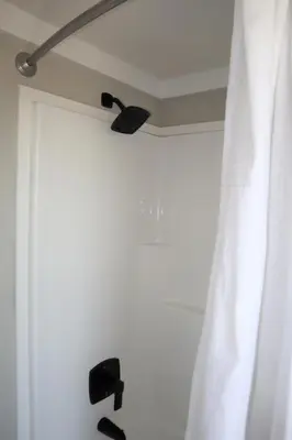 a shower with a white curtain and a window at Bayfront Resort at Cross View Site #28 in Sandusky