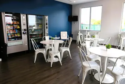 a restaurant with white tables and chairs and a drink cooler at Bayfront Resort at Cross View Site #28 in Sandusky