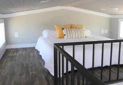 a bedroom with a bed with white sheets and pillows at Bayfront Resort at Cross View Site #28 in Sandusky