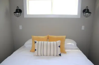 a white bed with two pillows and a window at Bayfront Resort at Cross View Site #28 in Sandusky