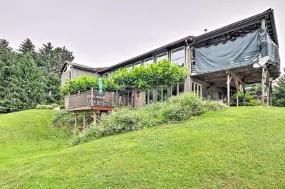 a house on top of a grassy hill at Mimis Place about Ohio Countryside Duplex with Deck in Orrville