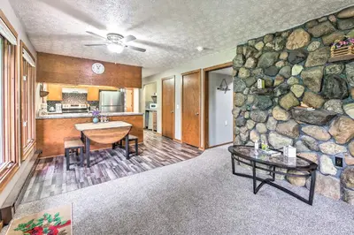a living room with a stone wall and a table at Mimis Place about Ohio Countryside Duplex with Deck in Orrville