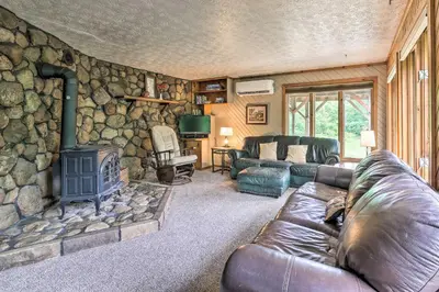 a living room with a couch and a stone wall at Mimis Place about Ohio Countryside Duplex with Deck in Orrville