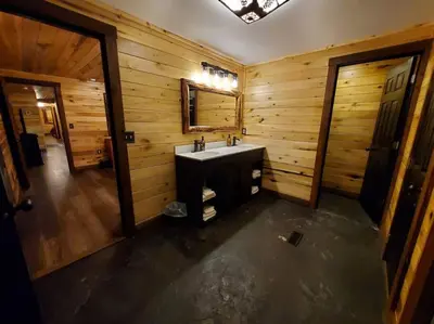a bathroom with a sink and a wooden wall at Luxury Cabin w/ Game Room & Hot Tub at Cave Run Lake in Wellington