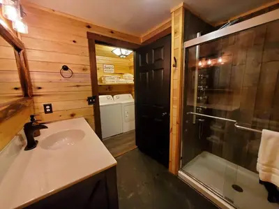 a bathroom with a sink and a shower in a cabin at Luxury Cabin w/ Game Room & Hot Tub at Cave Run Lake in Wellington